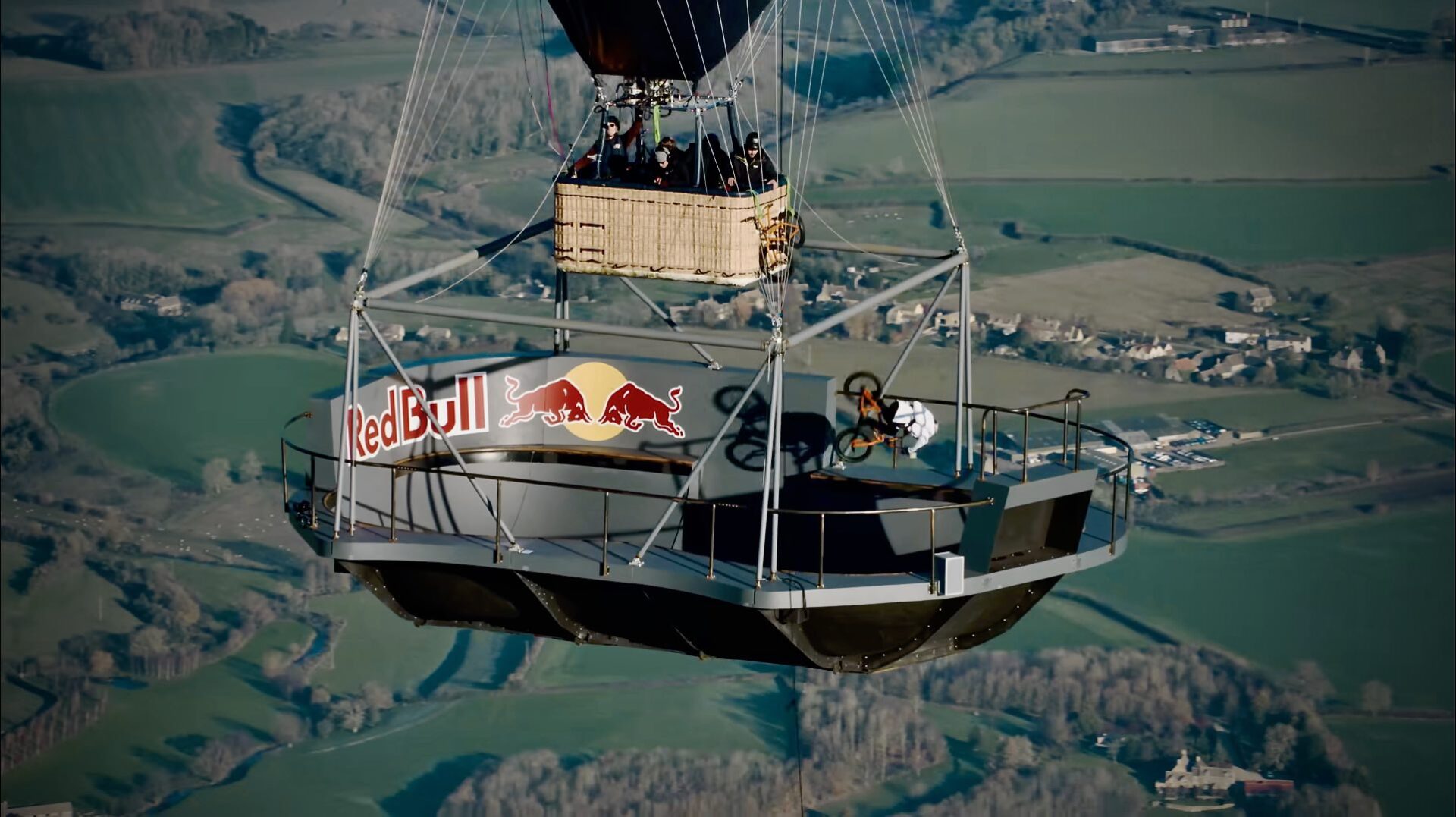 A Photo of BMX Rider Kris Kyle performing stunts in a BMX bowl suspended from a hot air balloon