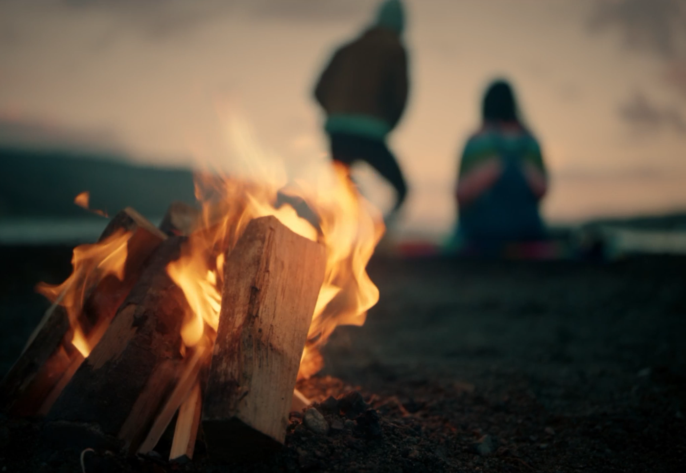 Picturesque Short Film - A shot of a fire with two people by a lake